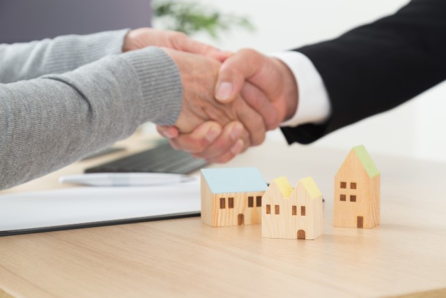 不動産会社で握手する2人の手