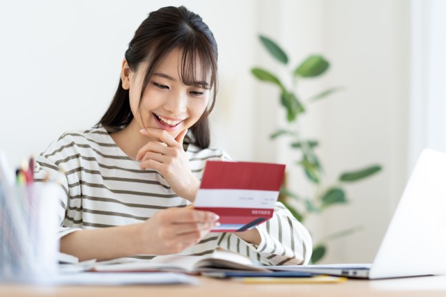 通帳を見て喜ぶ女性