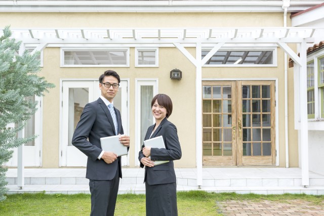 不動産の前に立つ男女