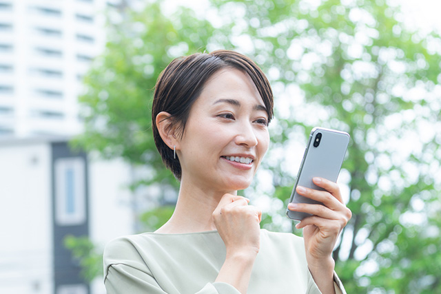 スマホで査定結果を見る女性