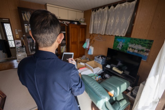 ものが多い実家を査定する男性