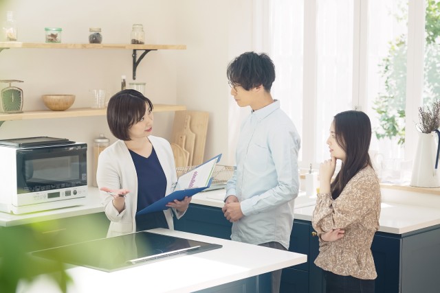 訪問査定中の夫婦と不動産会社の担当者