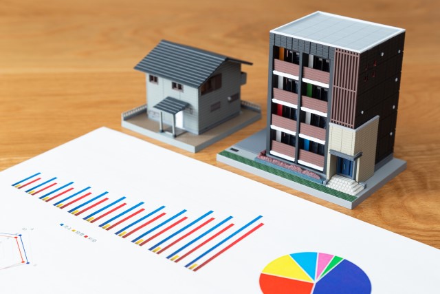 不動産仲介の実績を示すグラフと物件の模型