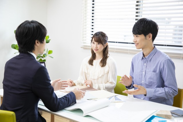 ハウスメーカーに土地を売ろうと相談する男女
