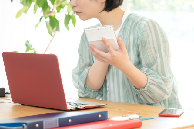土地売却にかかる税金を計算する女性