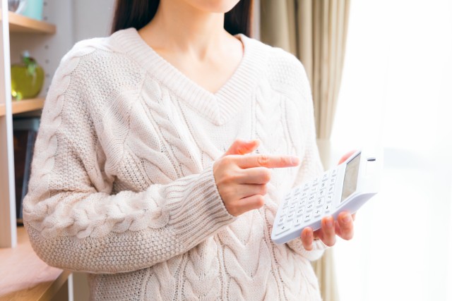 マンションにかかる費用を計算している女性