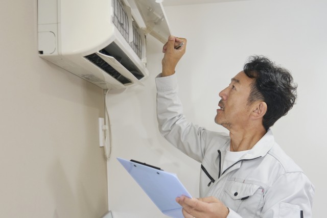 賃貸物件のエアコンを点検する人