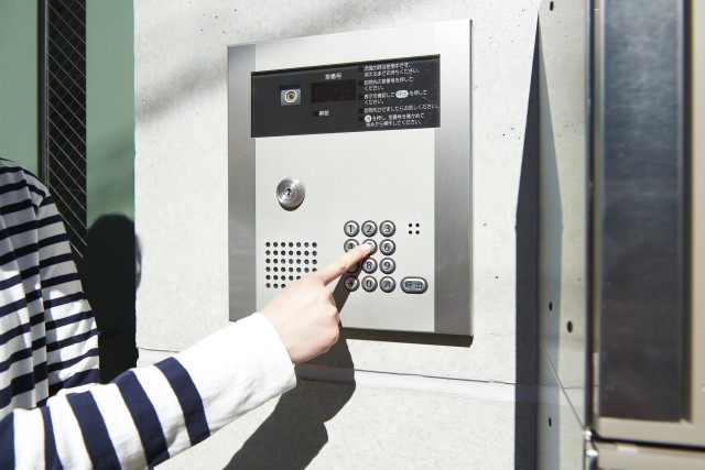 オートロックの暗証番号を入力する家主