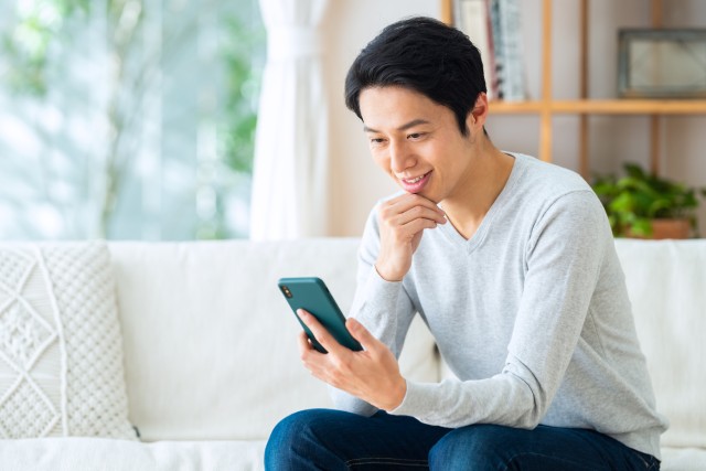 携帯電話でAI査定を行う人