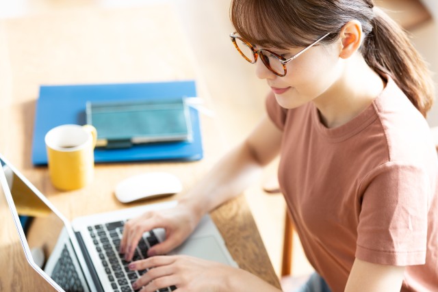 パソコンで家のシミュレーション査定をする女性