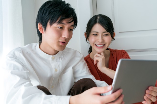 タブレットで家のシミュレーション査定をする夫婦
