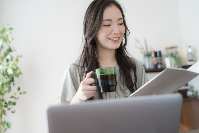 パソコンで用途地域について調べる女性