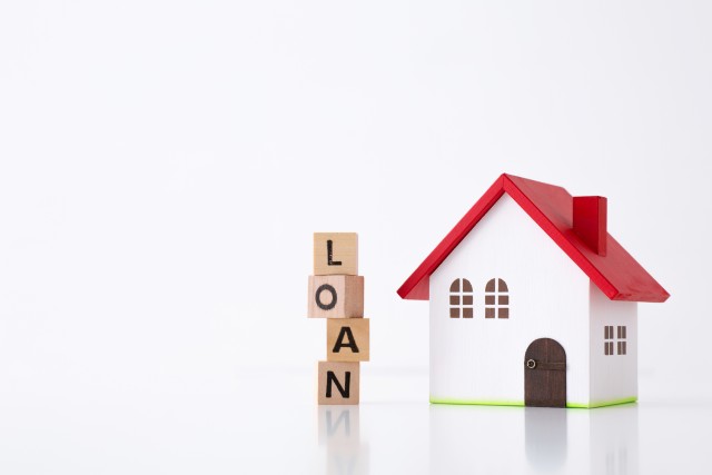家の模型と「LOAN」の英字ブロック
