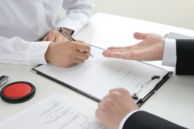 不動産仲介業者の説明を受ける人