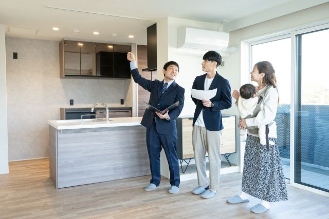 内見でキッチンを見る夫婦