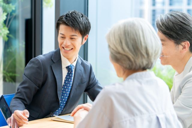 不動産会社の担当者から一般媒介契約の説明を受ける夫婦
