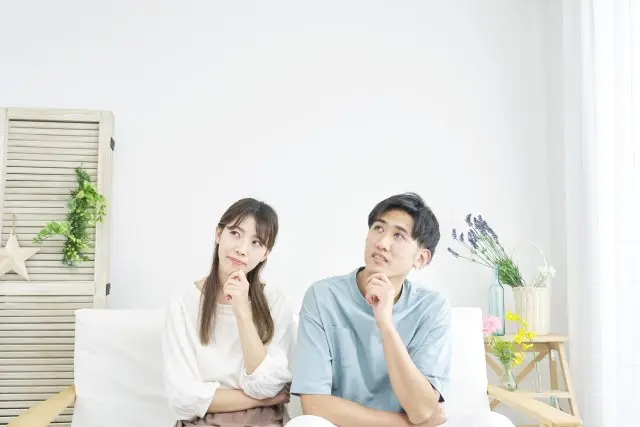 一緒に考えごとをしている若い夫婦